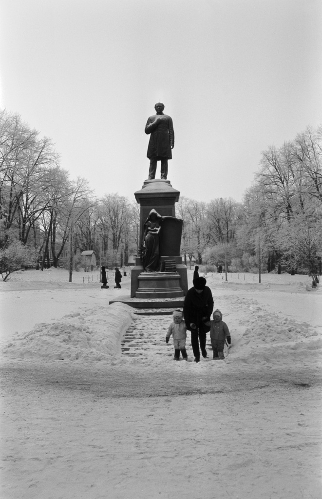 Runeberginesplanadi. Johan Ludvig Runebergin muistomerkki talvisessa Esplanadin puistossa. Nainen ja kaksi pientä lasta patsaan edessä. Paljon lunta.