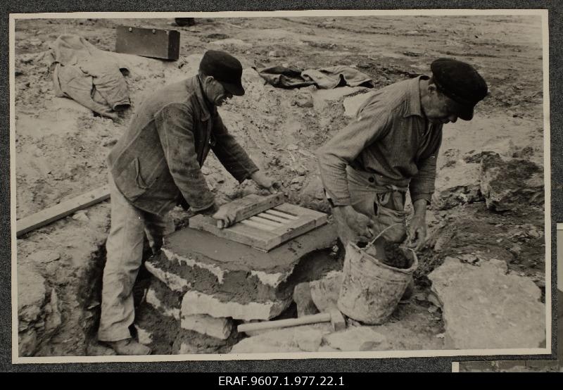 The workers place the sewerage resort in construction works of the new central market square.