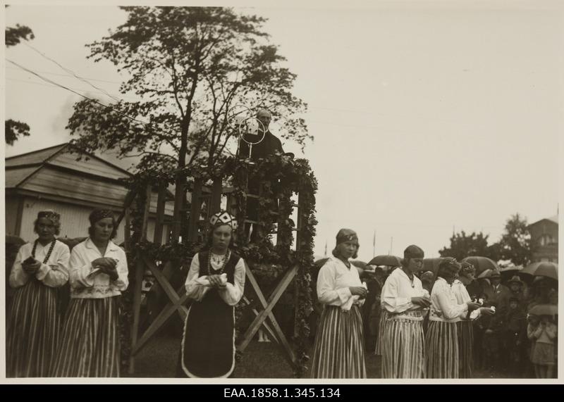 Jaan Tõnisson speaking at the Tartu Exhibition, in front of the ladies in clothes with white tubes