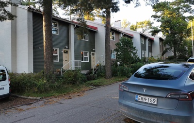 Länsi-Herttoniemi, Karhutie 26. Rivitalo. Kaksi lasta kävelee käsikädessä kuvan reunassa. Rivitalon edessä ulkona kaksi lastenvaunua. rephoto