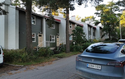 Länsi-Herttoniemi, Karhutie 26. Rivitalo. Kaksi lasta kävelee käsikädessä kuvan reunassa. Rivitalon edessä ulkona kaksi lastenvaunua. rephoto