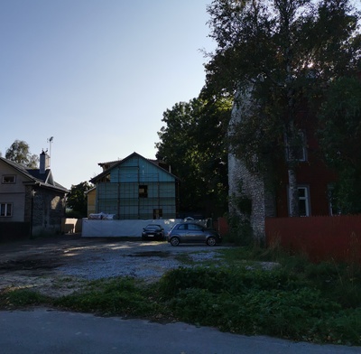 New-Kalamaja Street. Cars and car trucks between the houses on the parking lot. rephoto