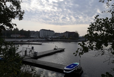 Näkymä Kasinonsaarelta Koululahden yli kaakkoon. Vasemmalla Kasinonsaaren silta. Koululahden etelärannalla Sikion talo ja taustalla Seurahuone. kesä 1908. View from Kasinonsaari over Koululahti to the southeast rephoto
