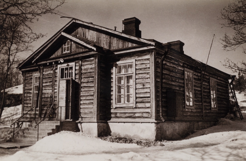 Hirsitalo Vallisaaressa. Rakennuksen molemmissa päissä oli sisäänkäynti ja talossa oli asunnot neljälle ruokakunnalle. Hirsitalo oli Lehmuskujan varrella lähellä Aleksanterin patteria. Rakennus purettiin 1960-luvun alussa.