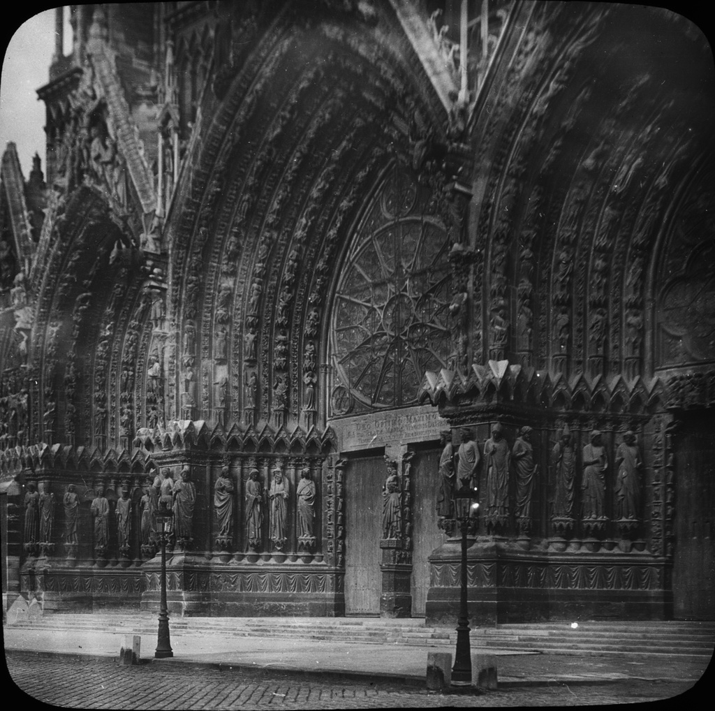 Skioptikonbild med motiv av Cathedral Notre Dame Reims.
Bilden har förvarats i kartong märkt: Höstresan 1910. Granada 9. Text på bild: "Rheims Katedral, vestportal".