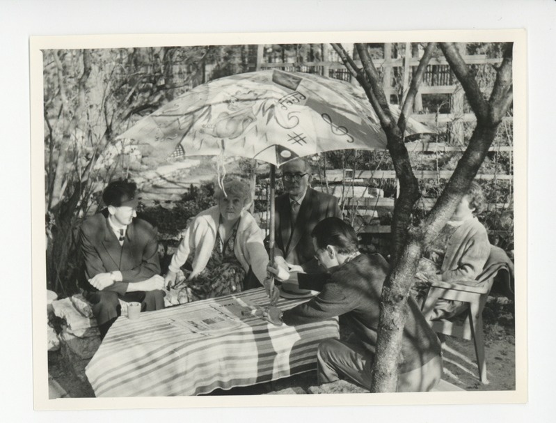 Tuglased külalistega aias päikesevarju all