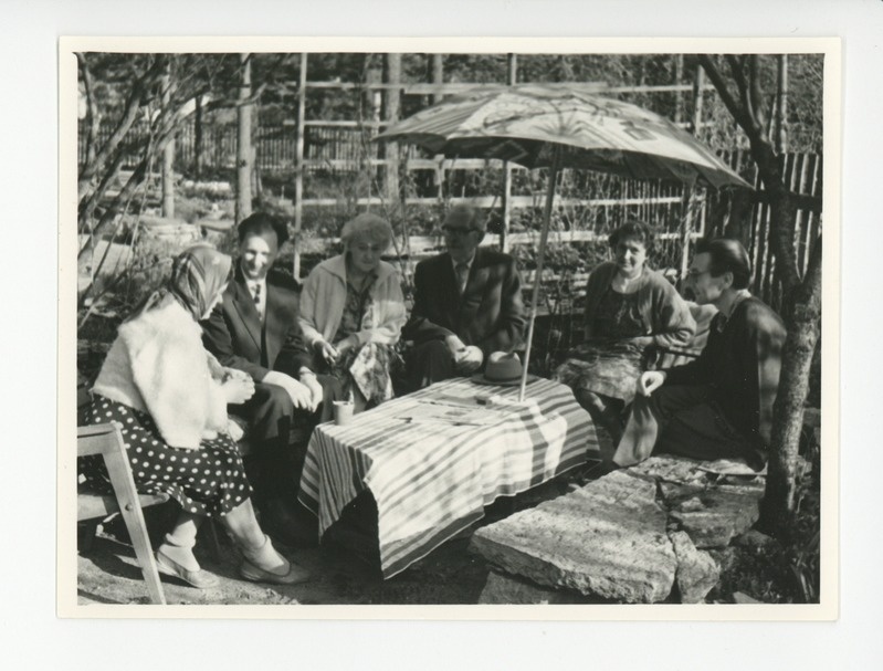 Tuglased külalistega aias päikesevarju all