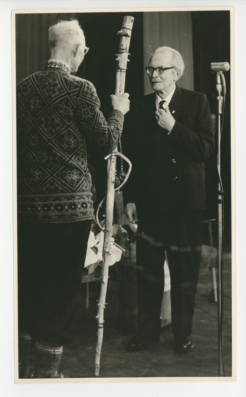 V. Randmets annab Friedebert Tuglasele 80. juubeliaktusel kingituseks matkakepi