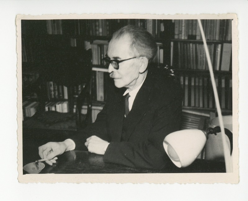 Friedebert Tuglas oma töökabinetis kirjutuslaua taga suitsetamas