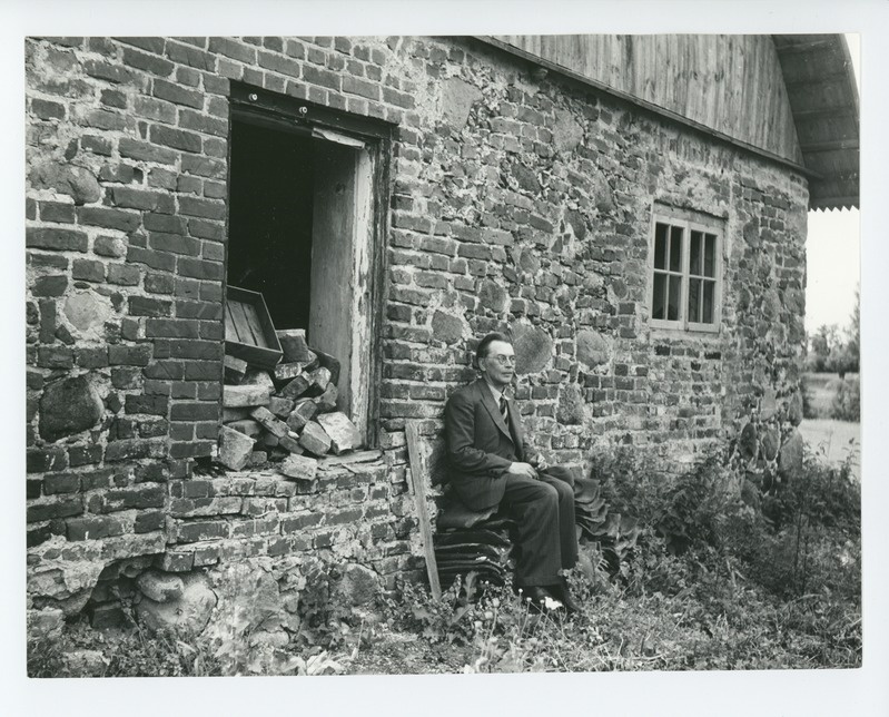 Friedebert Tuglas Ahjal vana õllekoja seina ääres, 1938