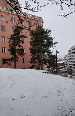 Kolme tyttöä istumassa kallioilla Katri Valan puistossa, takana Vilhonvuorenkuja 20. rephoto