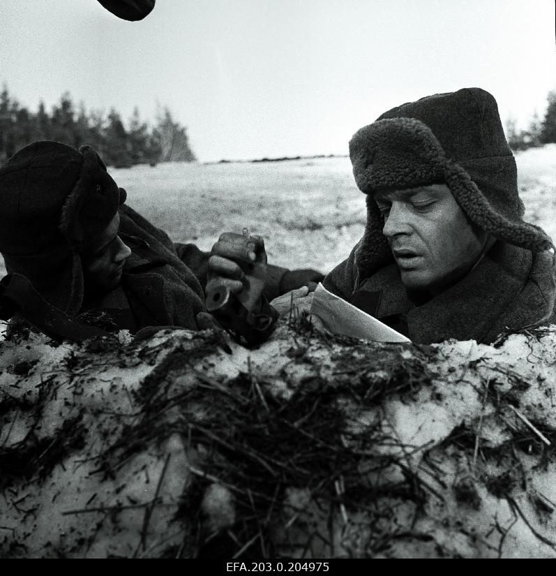 A scene from the Tallinn Film game film "People in Soldiers". Warriors in snowy mining. Tisler (Rein Juurik) reads a letter from the homes, next to him in Veski (Arvi Hallik).
