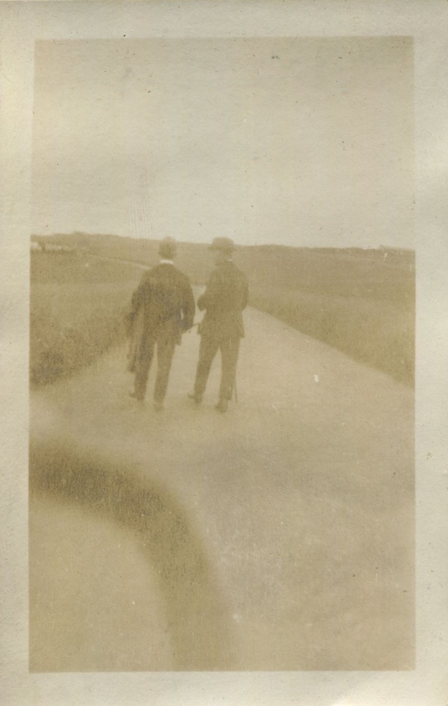 Two men walking away along a path