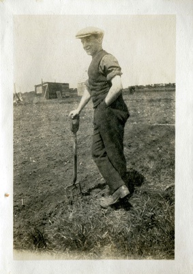 Man in a field learning on a fork  duplicate photo