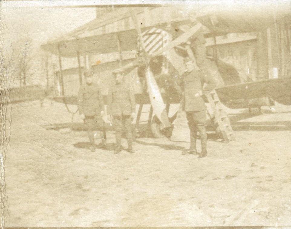 Four men posing round a bi-plane, possibly at RAF Beaulieu