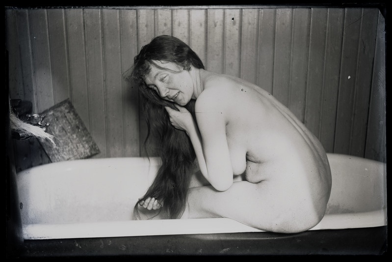 Naine juukseid pesemas (akt).