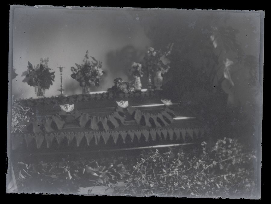 Matusefoto, lilledega ümbritsetud suletud kirst.