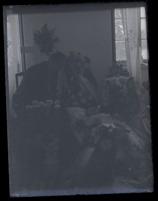 Matusefoto, naine avatud kirstus, kirstu kõrval istub meesterahvas.  duplicate photo