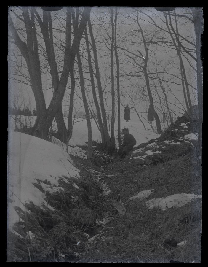 Maastikuvaade, pildistatud kraavipervelt, vaatega teele. Teel seisab kaks inimest, üks istub kraavipervel.