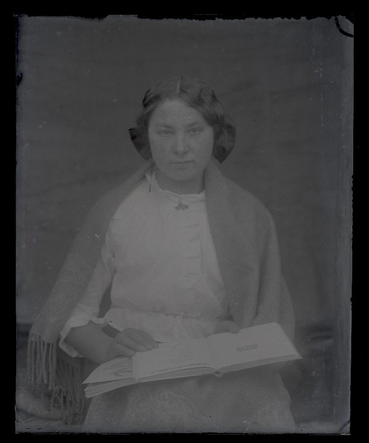 Naise portee, süles kaks raamatut.