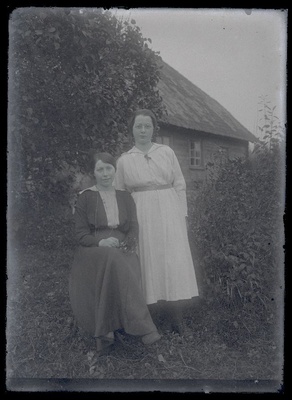 Kaks naisterahvast, taustal talumaja.  duplicate photo