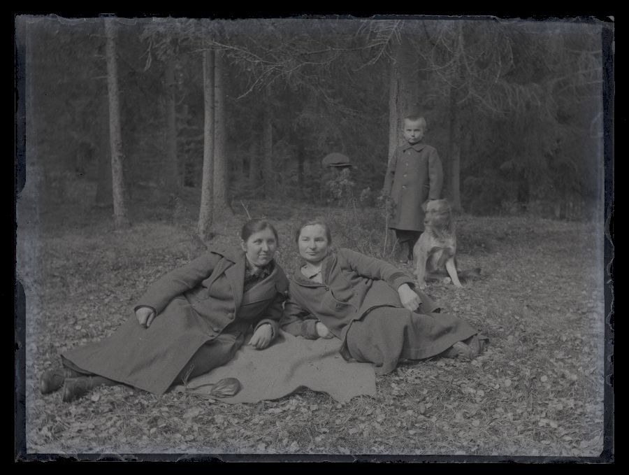 Grupifoto, kaks naist väike laps ja koer metsas.