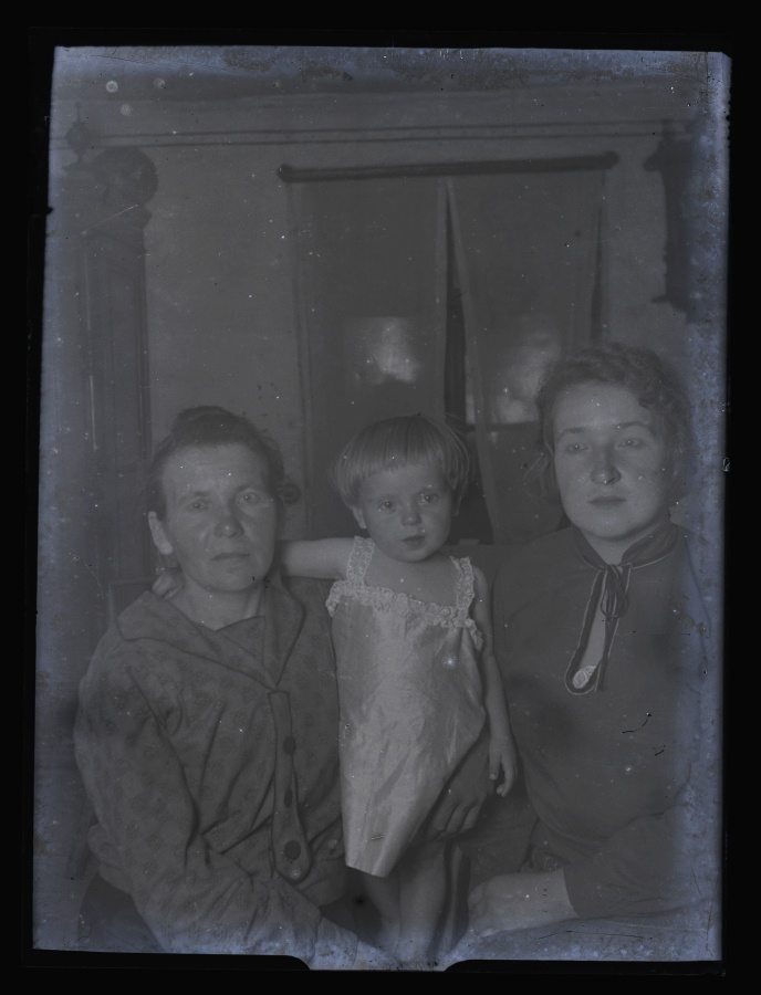 Kaks naist ja väike laps poseerivad fotograafile.