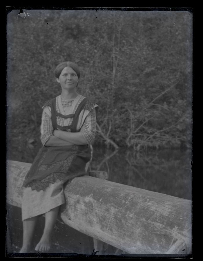 Naine istumas jõeäärsel piirdel.