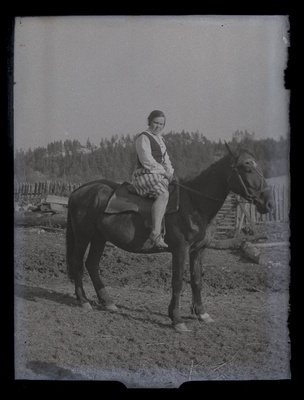 Naine hobuse seljas, taustal lippaed.  duplicate photo