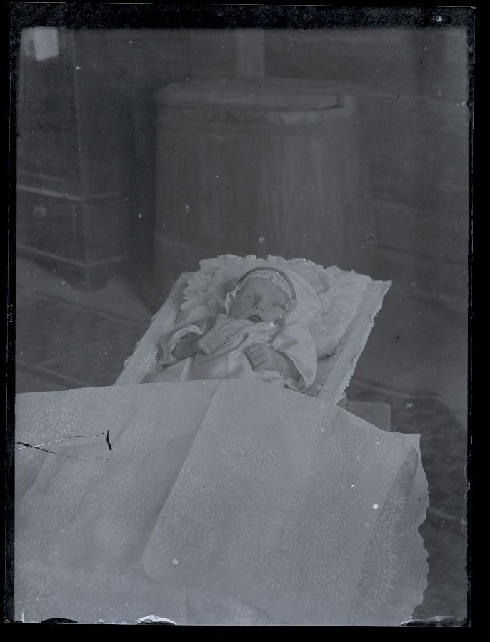 Matusefoto, väikese lapse surnukeha avatud kirstus.