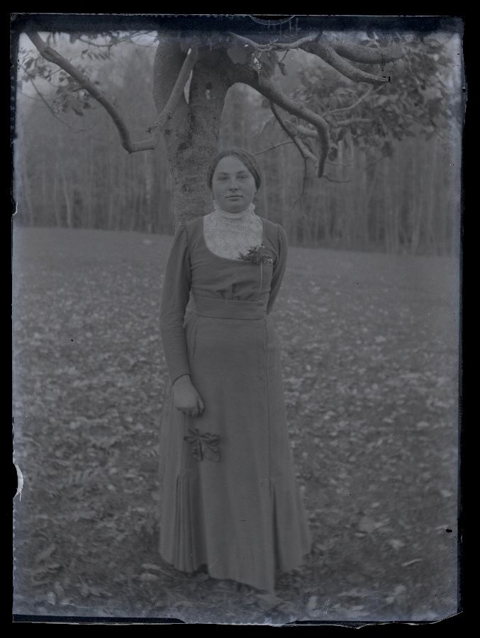 Noor naine vabas õhus, poseerib puu taustal.