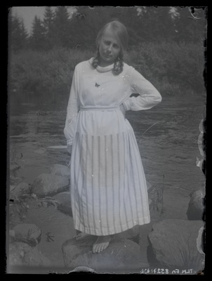 Neiu seismas kivil veekogu taustal, umbes 1920. aastast.  duplicate photo