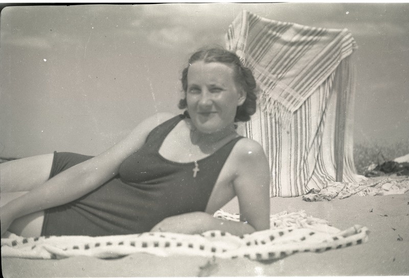 Noor naine supelkostüümis rannas lebamas.