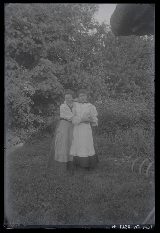 Portreefoto, naine ja neiu seismas looduslikus keskkonnas, umbes 1915. aasta.