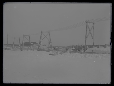 Talvine vaade mingile rajatisele - silla- või tammiehitusele, esiplaanil elektriliin, umbes 1910. aasta.  duplicate photo