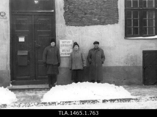 Employees of the Tallinn City State Archive V. Juuriksoo, e. Vendla and J. Ilves in front of the external door of the archive in the winter of 1964.