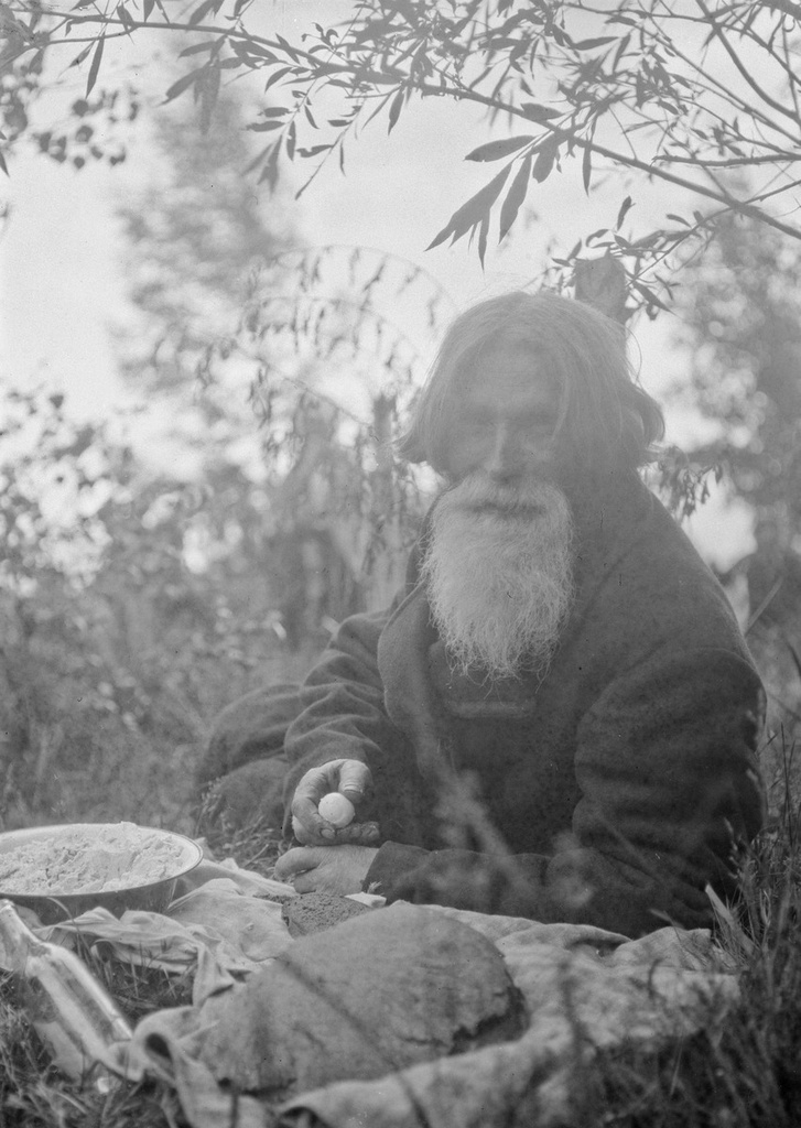 An old man eating memorial at the grave