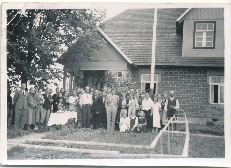 Grupifoto: Einerite suguvõsa liikmete kokkutulekust osavõtjad Pisuksel elumaja veranda ees õues.