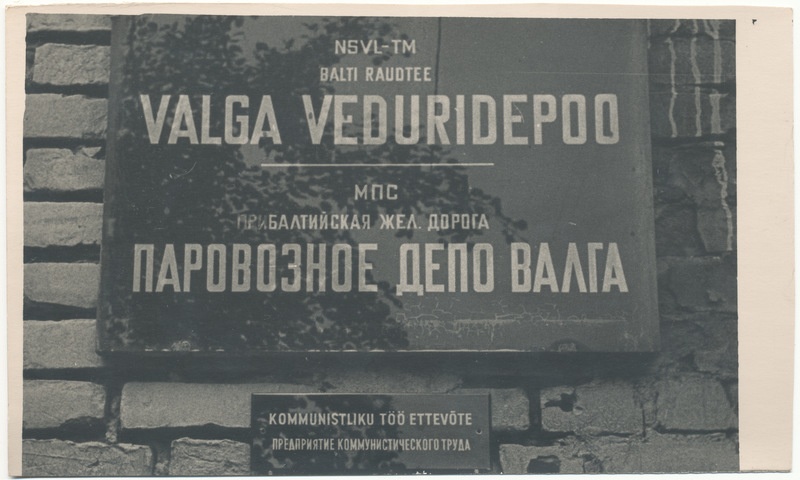 Valga Veduridepoo. Kommunistliku töö ettevõtte nimetuse silt kontoriukse kõrval seinal (eesti ja vene keeles).