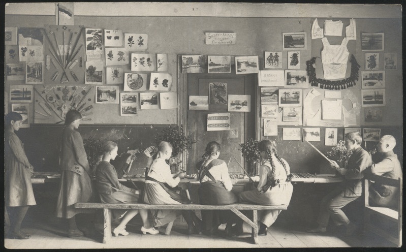 fotopostkaart, Suure-Jaani khk, Suure-Jaani kihelkonnakool, sisevaade, käsitöönäitus, õpilased laua ääres meisterdamas, u 1925