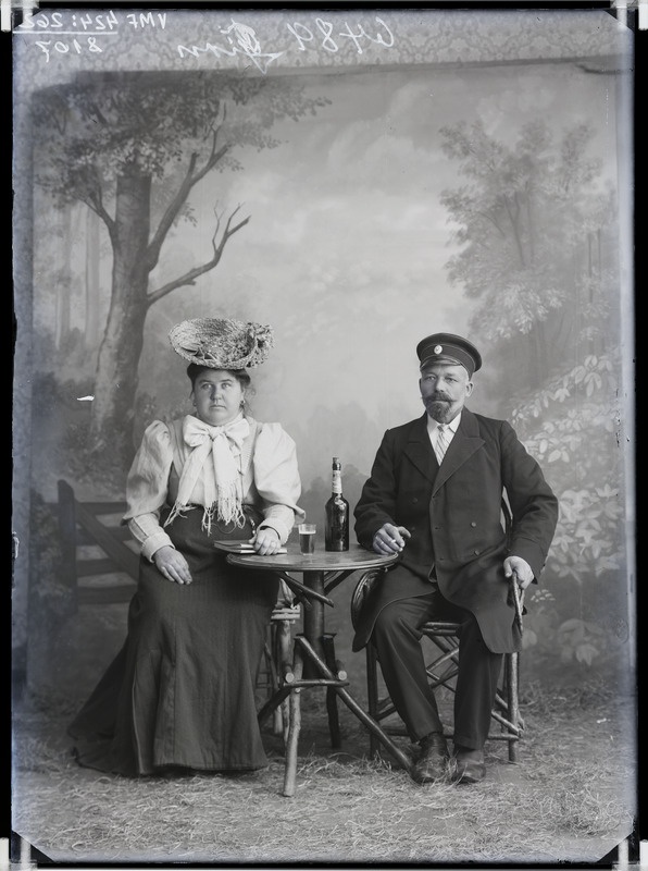 fotonegatiiv, Girn, vanem paar, laud, pudel, klaas, kübar, täisportree, 1906 foto J. Riet