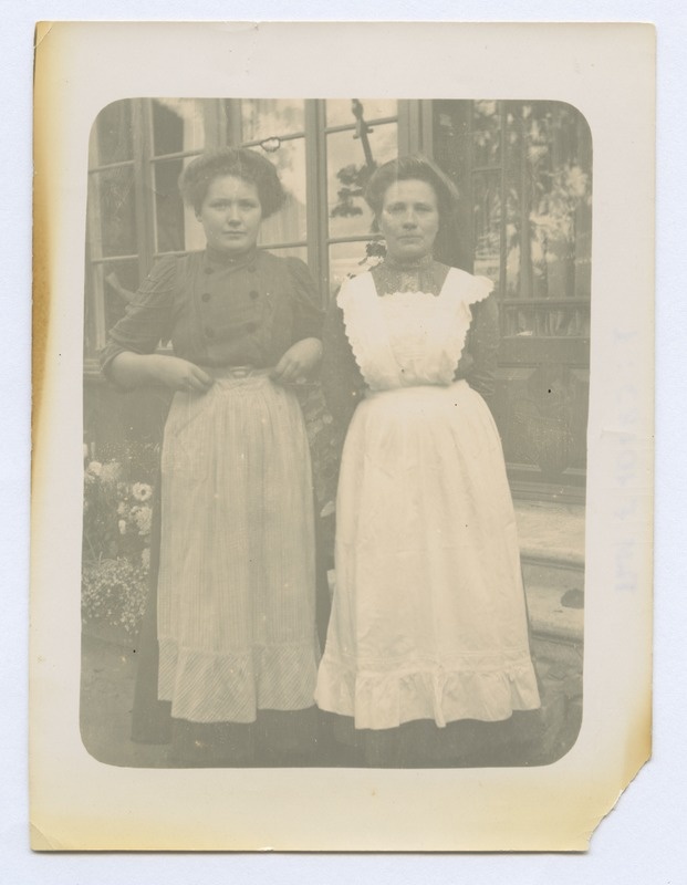 Kaks teenijannat maja ees.