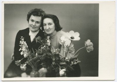 Evi Lemberg koos sõbrannaga. Nende ees lilled. Portree. Ateljeefoto.  duplicate photo