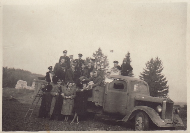 Group photo, fire-fighting form men and women in the truck box and in front of it.