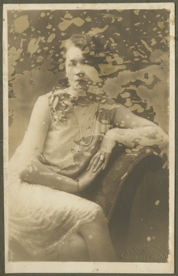 Naine õhukeses kleidis leentoolis. Portree kolmveerand pikkuses. Kleebitud papile. Ateljeefoto.  duplicate photo