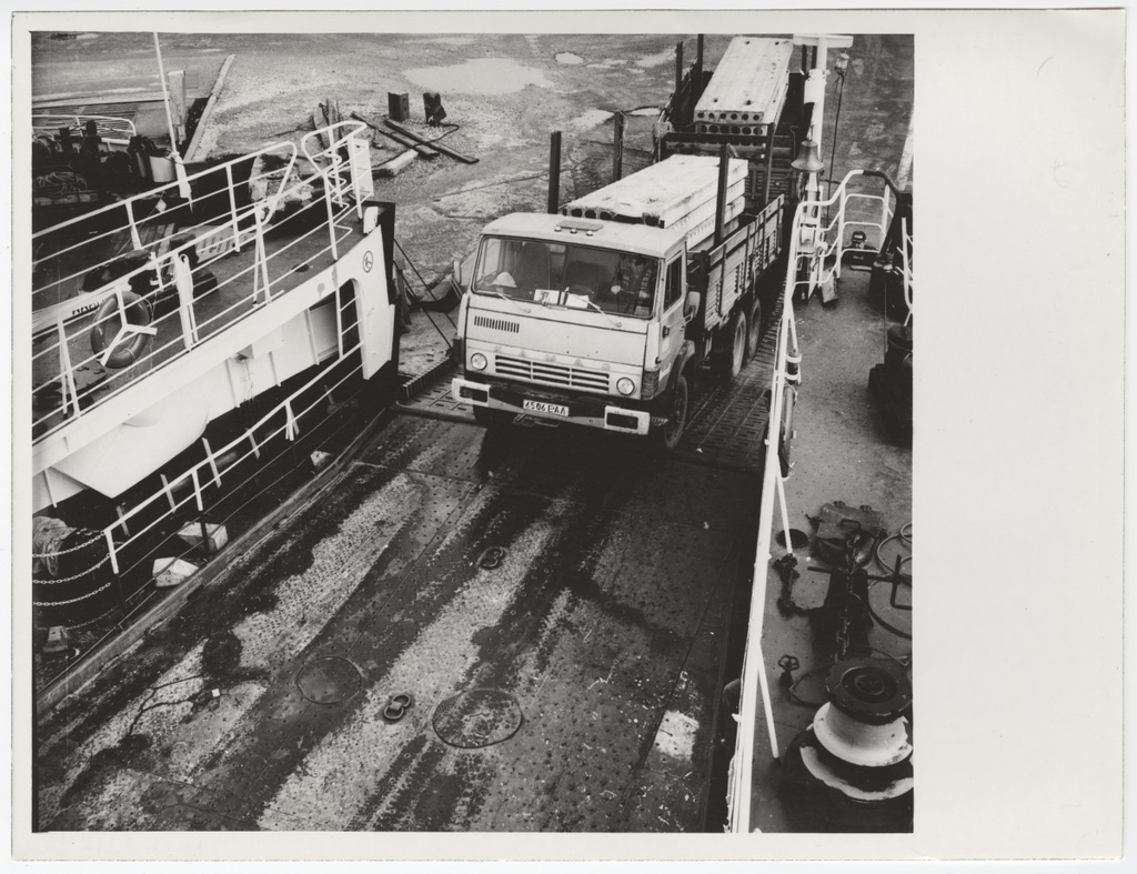 A truck with a trailer drives to the "Harilaid" ferry. The load of the truck is construction panels.