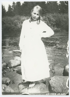 Neiu seismas kivil veekogu taustal, umbes 1920. aastast.  duplicate photo