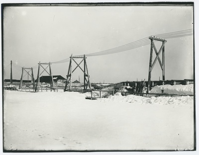 Talvine vaade mingile rajatisele - silla- või tammiehitusele, esiplaanil elektriliin, umbes 1910. aasta.  duplicate photo
