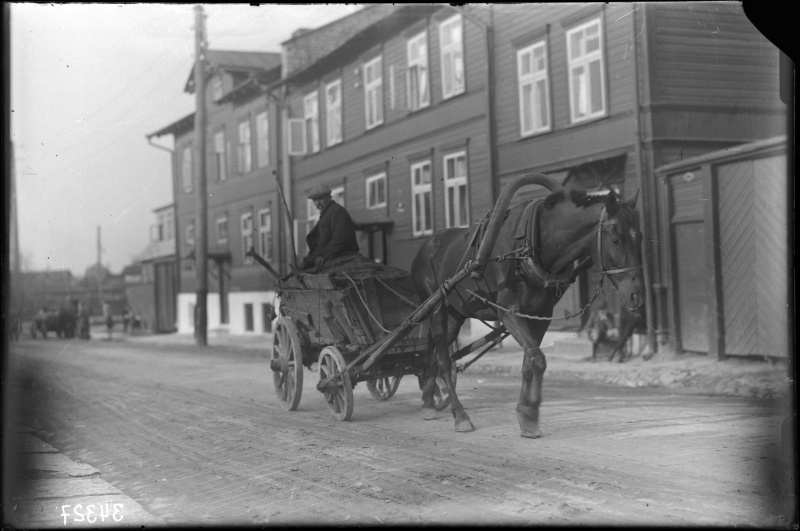 Cleaner of lamp boxes with horse riding on the city street.