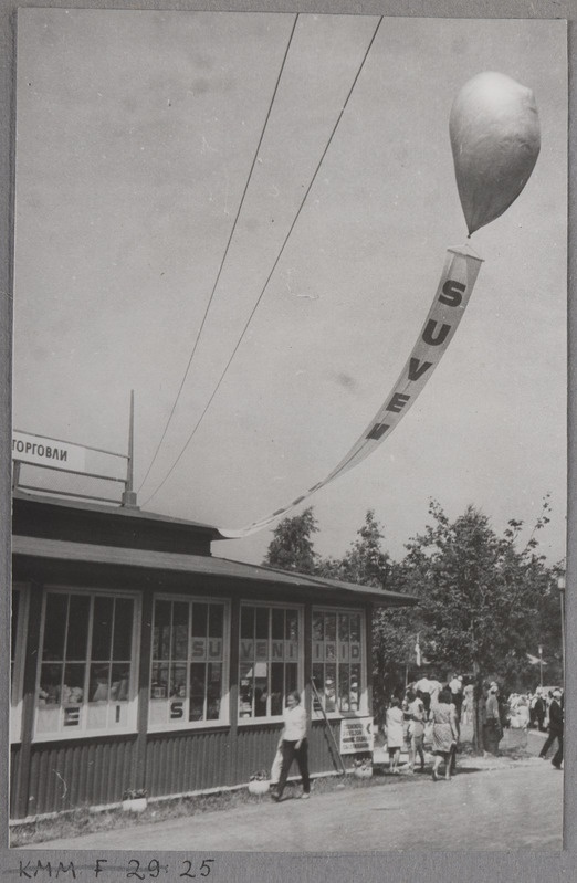 Tallinna Kaubamaja paviljon Tallinna Lauluväljakul. 100. juupelilaulupeo ajal. Kaubamaja reklaamsildi õhku lennutamise moment.